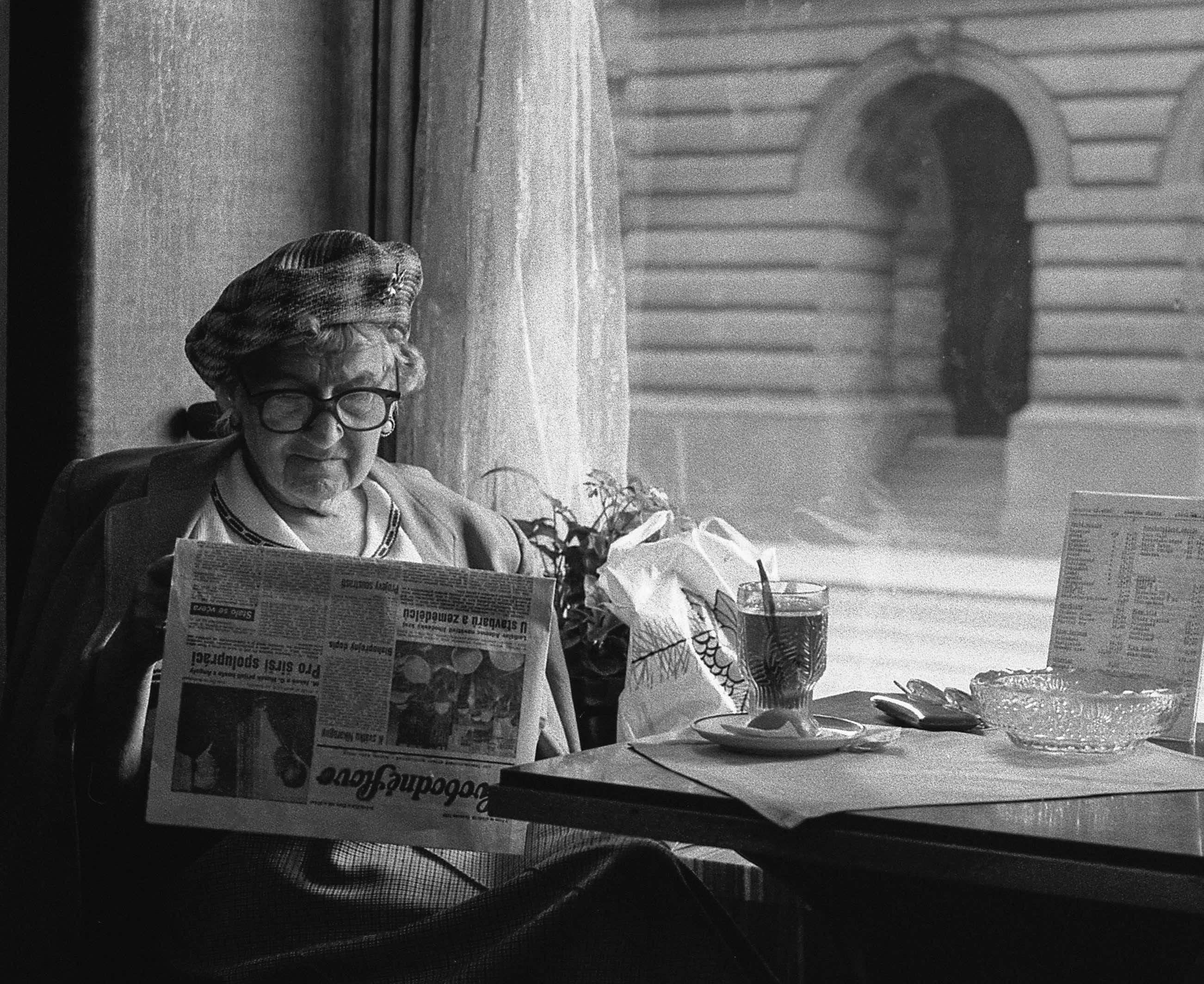 A woman reads a newspaper. You can learn to write reviews that sell.
